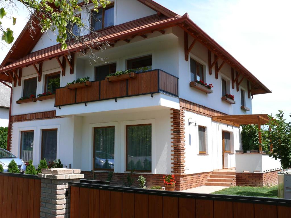 a house with a balcony and a fence at Sára Apartman in Hévíz