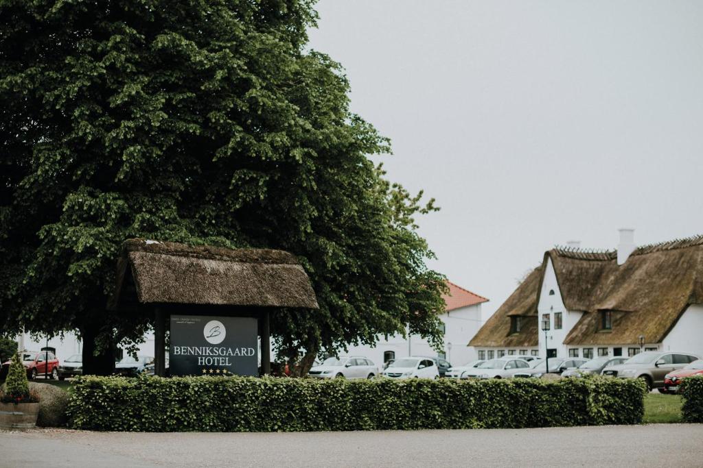 a sign in front of a building with a thatch roof at Benniksgaard Hotel in Gråsten