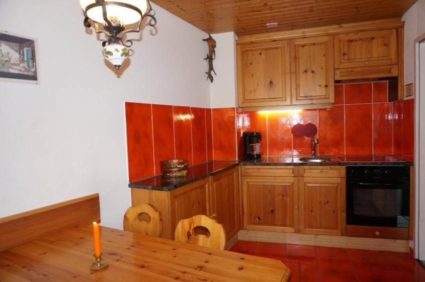 een keuken met houten kasten en een houten tafel bij Paradies 026 in Arosa