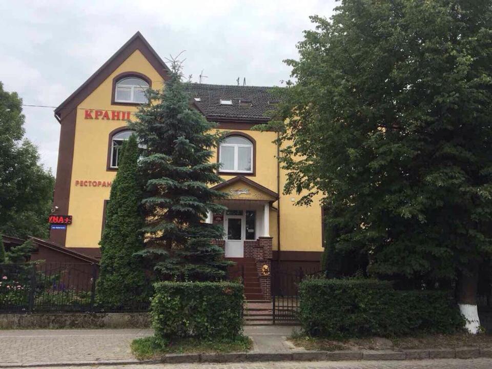 a yellow house with a tree in front of it at Cranz Hotel in Zelenogradsk