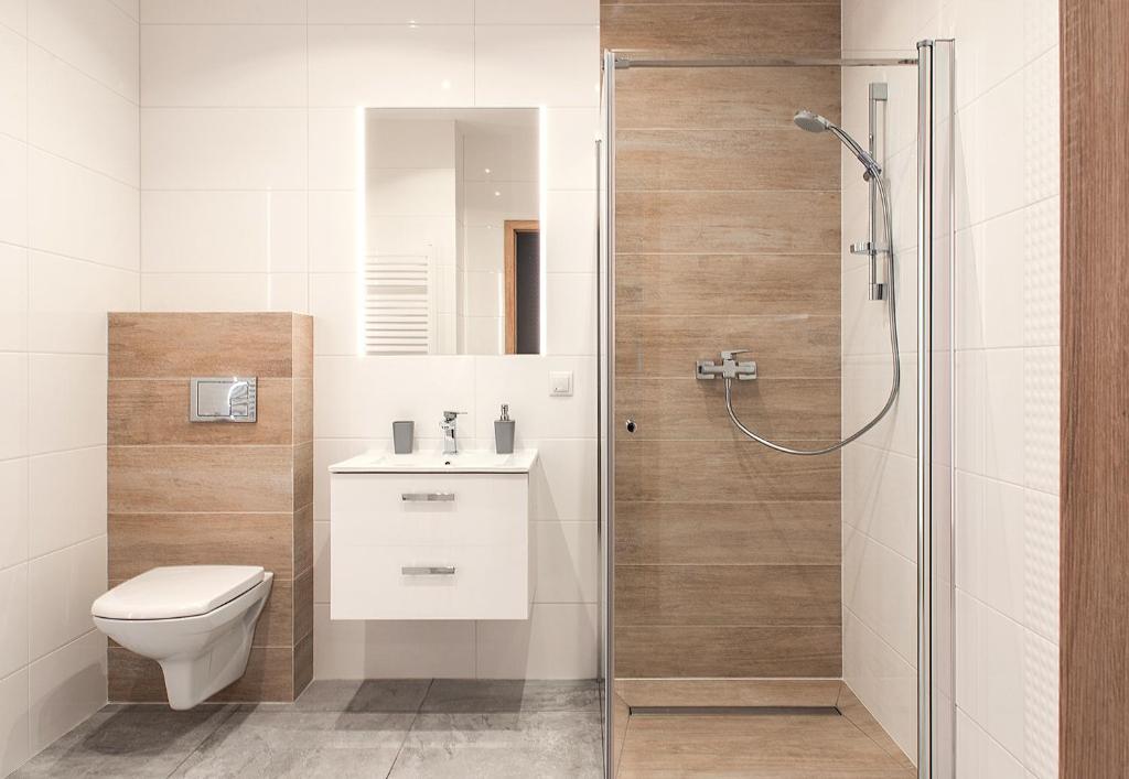 uma casa de banho com um chuveiro, um WC e um lavatório. em Apartament w Bizancjum 9 PARKING FREE 24H em Klodzko