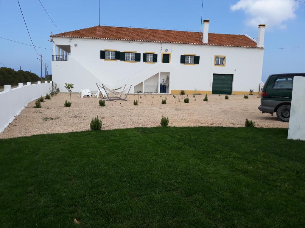 a white house with a lawn in front of it at I Ka Hale in Vila Nova de Milfontes
