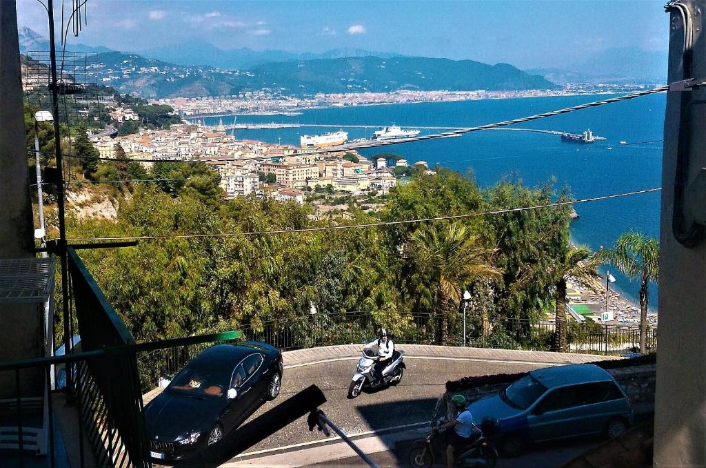 a person riding a motorcycle on a road near the water at LA SCALINATELLA -vista mare- in Vietri sul Mare