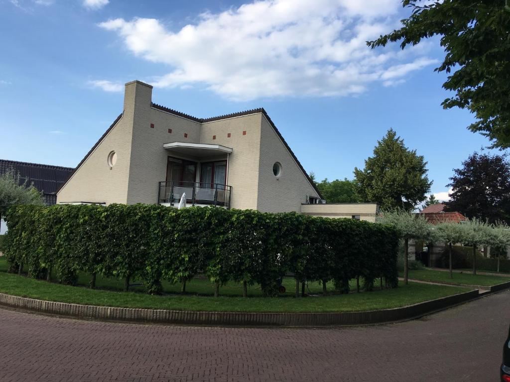 une maison avec une haie devant un bâtiment dans l'établissement La Nuova Casa del Campo (vh De Kamp), à Dinxperlo