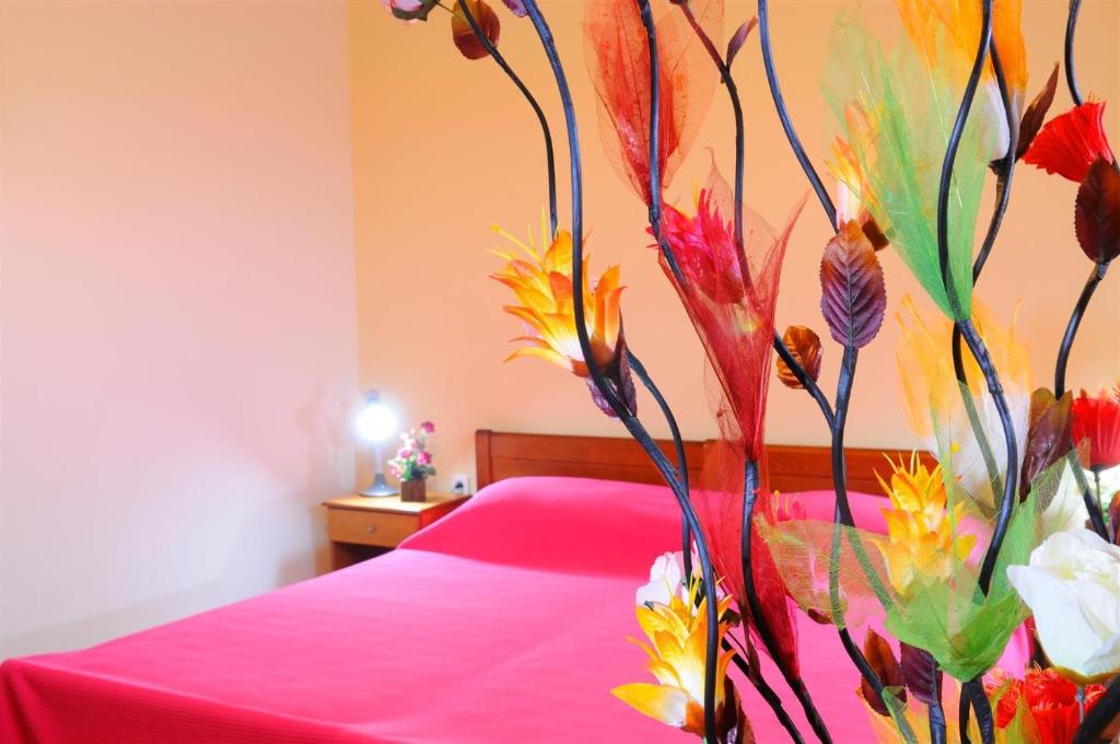 een slaapkamer met een roze bed met een bloemenmuur bij Nikos 2 Studios & Apartments in Kardamaina