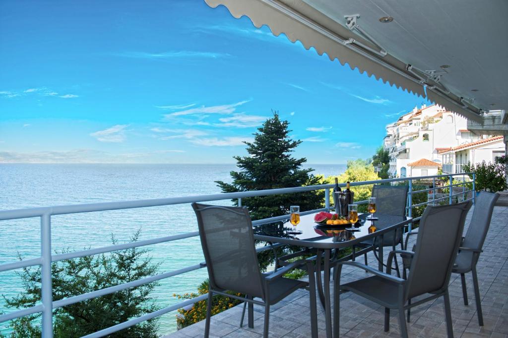 a table and chairs on a balcony overlooking the ocean at Kiveri Luxurious Seaside Apartment in Kiveri