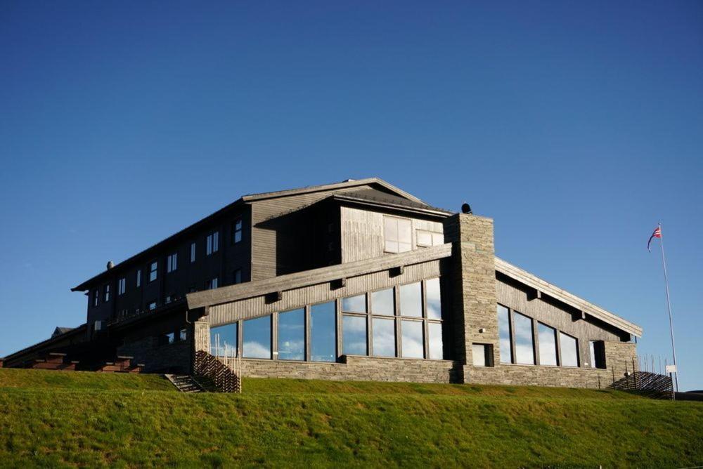 un edificio en la cima de una colina con césped en Pellestova Hotell Hafjell en Hafjell