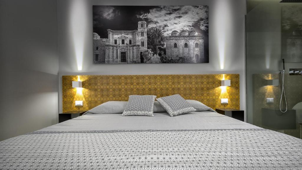 una camera da letto con un grande letto con due cuscini di Suite del Ponte Normanno a Palermo