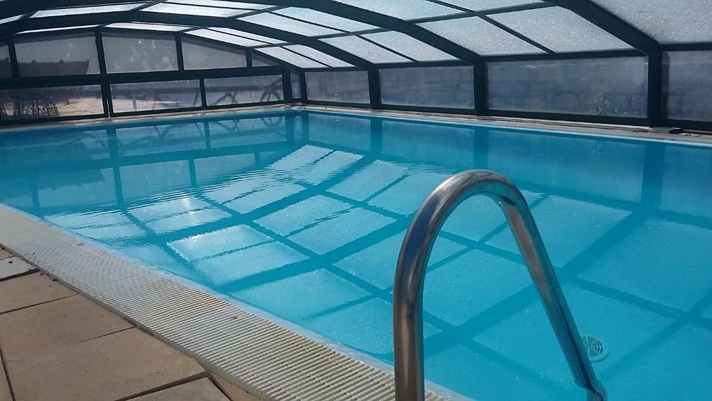 - une grande piscine d'eau bleue dans un bâtiment dans l'établissement Logis Hôtel restaurant Auberge de la Cascade, à Sainte-Énimie