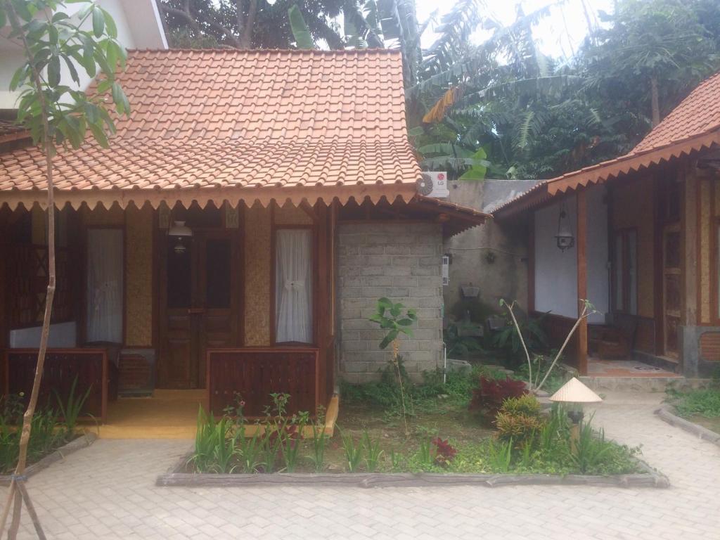una pequeña casa con techo rojo en Diana's Homestay en Banyuwangi