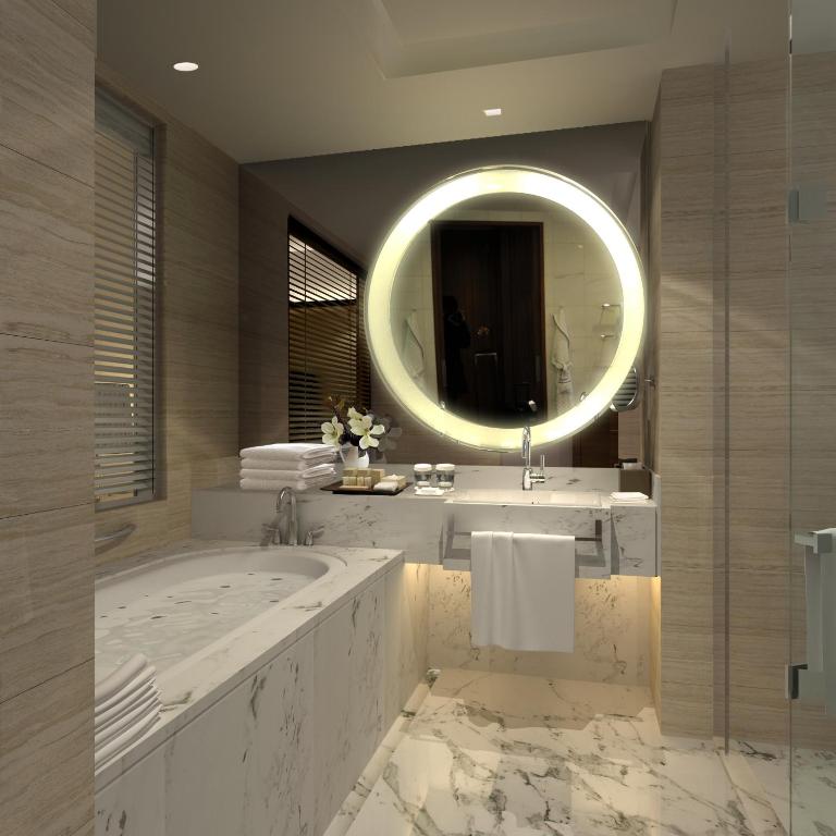 a bathroom with a large tub and a large mirror at Shanghai Hongqiao Airport Hotel - Air China in Shanghai