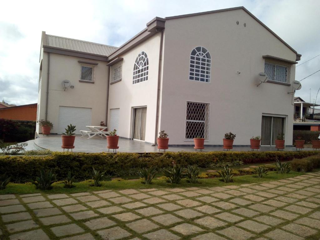 a white house with potted plants in front of it at Sahamalaza in Ivato