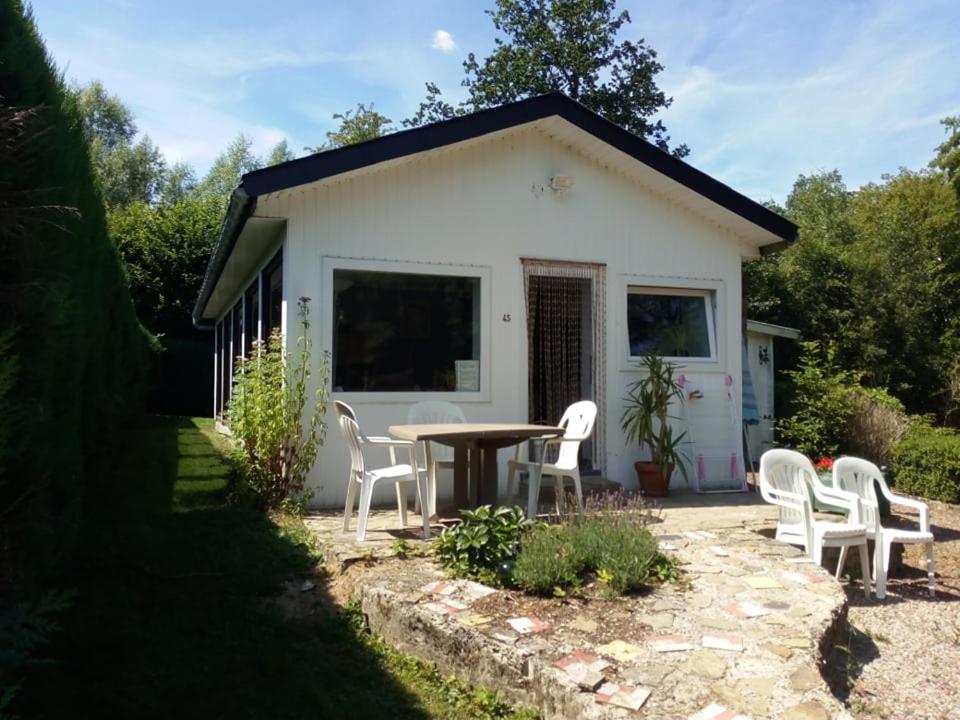 a table and chairs in front of a house at chalet de la vallée des prés in Oignies-en-Thierache