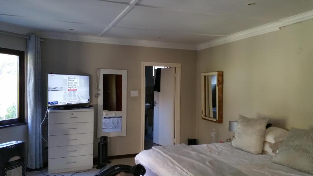 a bedroom with a bed and a flat screen tv at Johannesburg Youth Hostel in Johannesburg