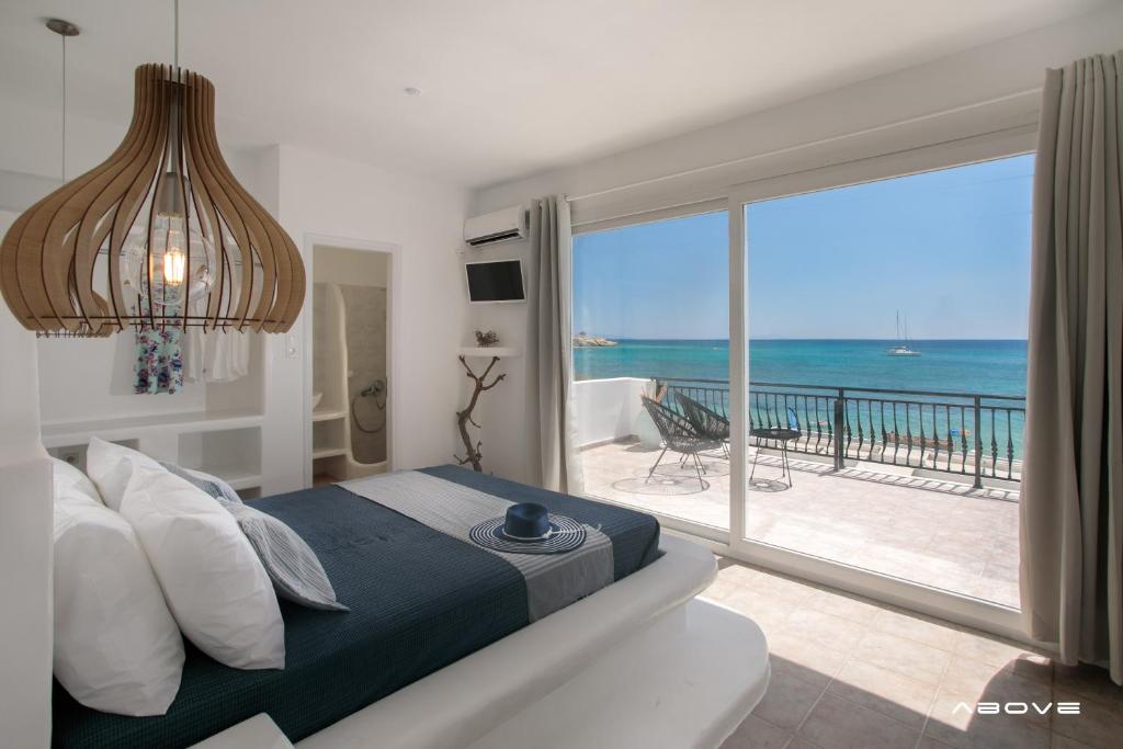 a bedroom with a bed and a view of the ocean at Manios Suites in Agia Anna Naxos