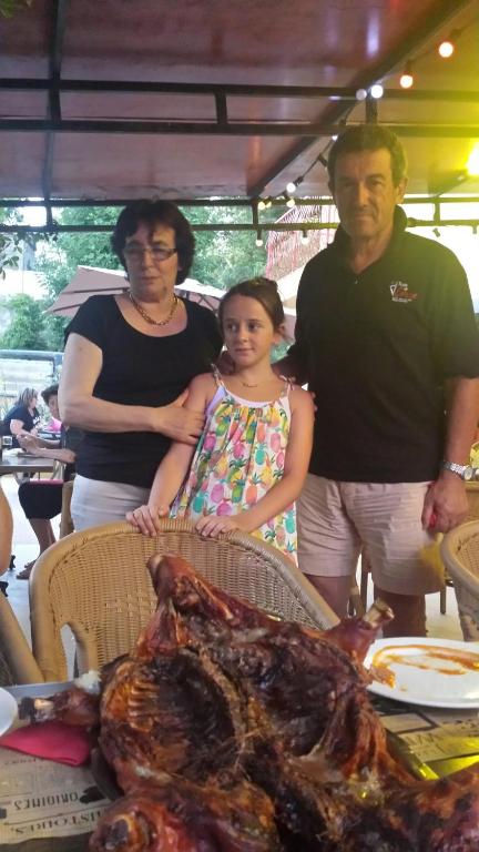 a family standing in front of a table with a turkey at Le FLORIDA in Zicavo