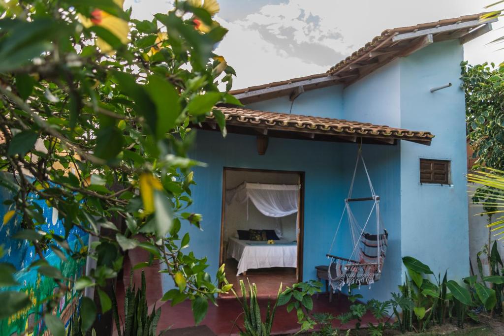 a blue house with a bed in the doorway at Casa Azul Caraíva - Casas Do San in Caraíva