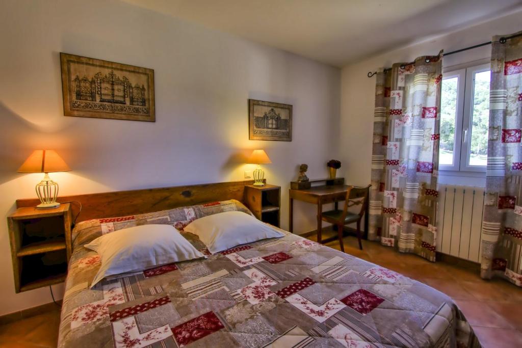 a bedroom with a bed with a quilt on it at A Ghjuvellina in Piedigriggio
