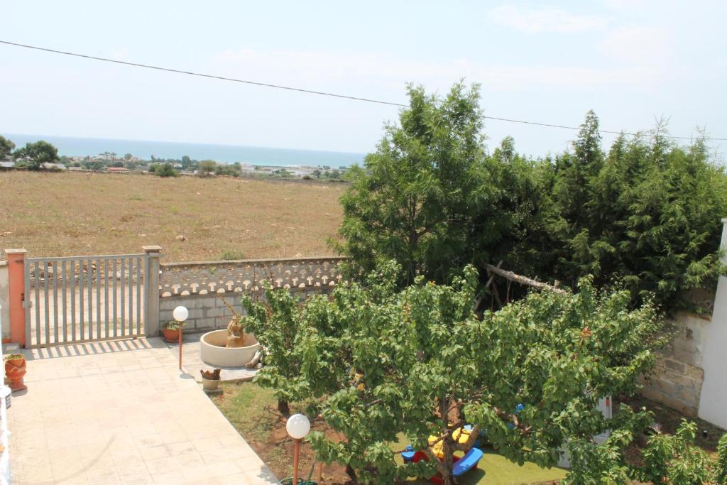 a garden with trees and a fence and a field at Villetta Lu Sule in Porto Cesareo