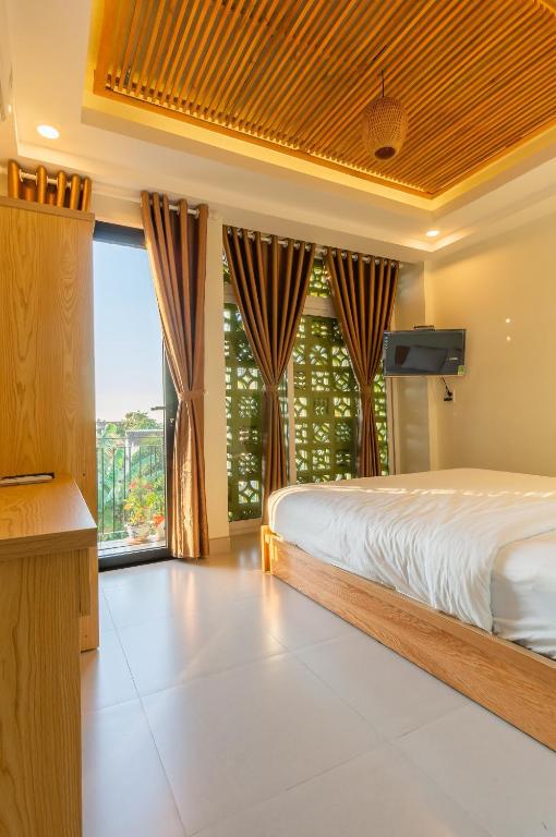Un dormitorio con una cama y una ventana grande. en D Central Hoi An Homestay, en Hoi An