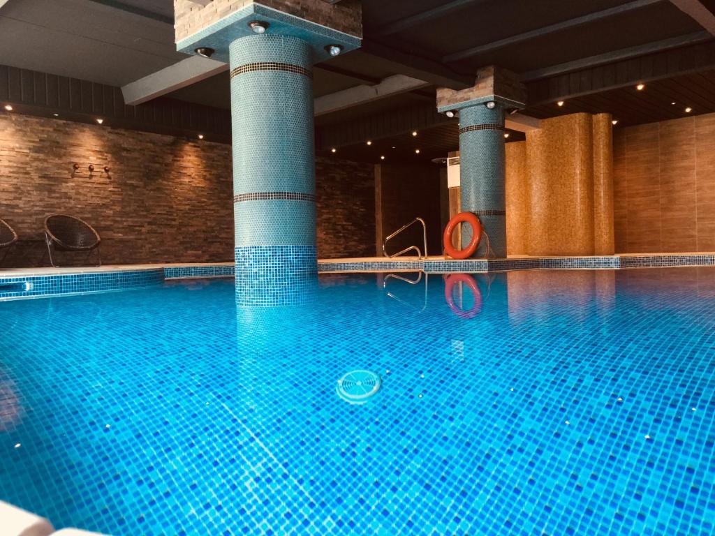 a large swimming pool in a building with columns at Cumberland Hotel - OCEANA COLLECTION in Bournemouth