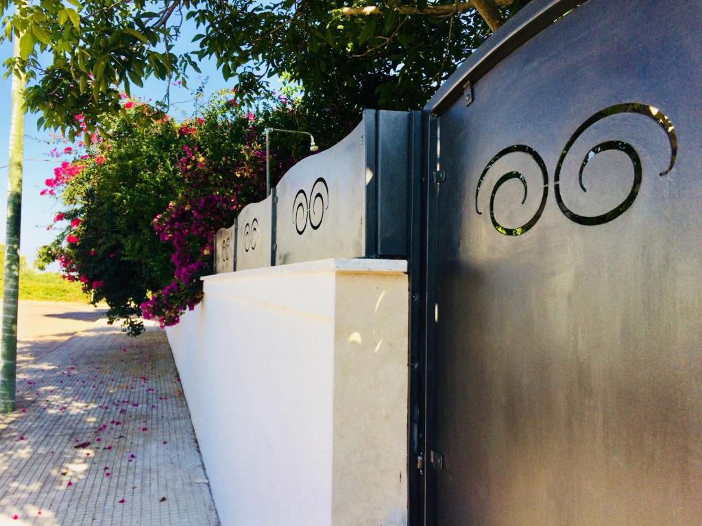una recinzione con dei numeri sopra, accanto a un marciapiede di casa La sorgente di Carlo Magno a Otranto