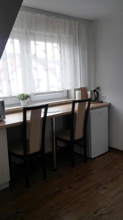 a kitchen with a table and chairs and a window at Apartamenty Pod Telegrafem in Kielce