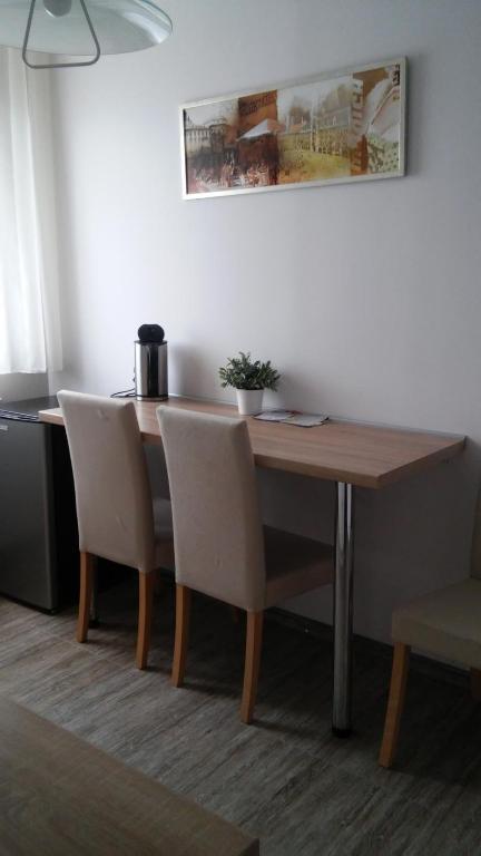 a dining room table with two chairs and a table at Apartamenty Pod Telegrafem in Kielce