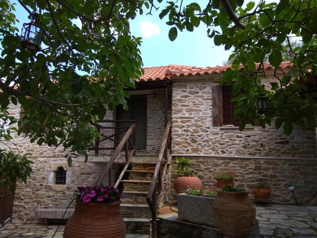 a stone house with stairs leading to a door at Pelion Zervochia in Afissos