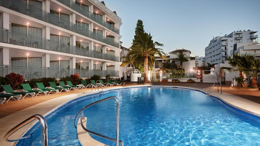 uma grande piscina em frente a um edifício em Hotel Villa Flamenca em Nerja