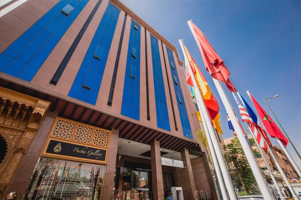 un bâtiment arborant des drapeaux colorés devant lui dans l'établissement Hotel Almas, à Marrakech