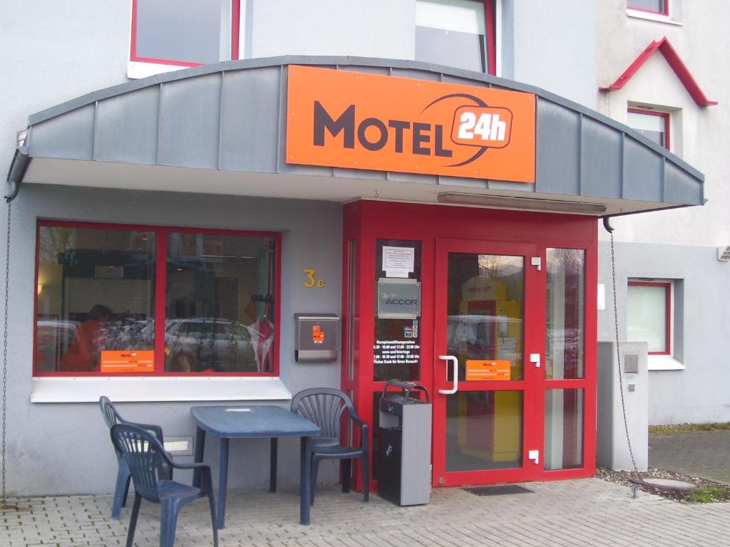 motel ze stołem i krzesłami poza nim w obiekcie Motel 24h Bremen w Bremie