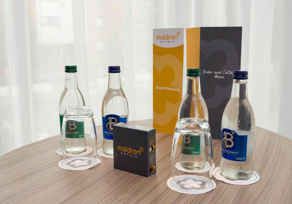 a group of bottles of water and glasses on a table at Maldron Hotel Kevin Street, Dublin City in Dublin
