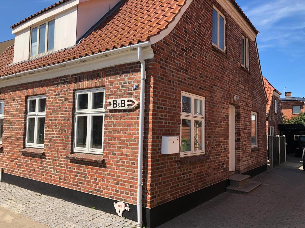 a brick building with a sign on the side of it at Bredgade 10 Thyborøn in Thyborøn