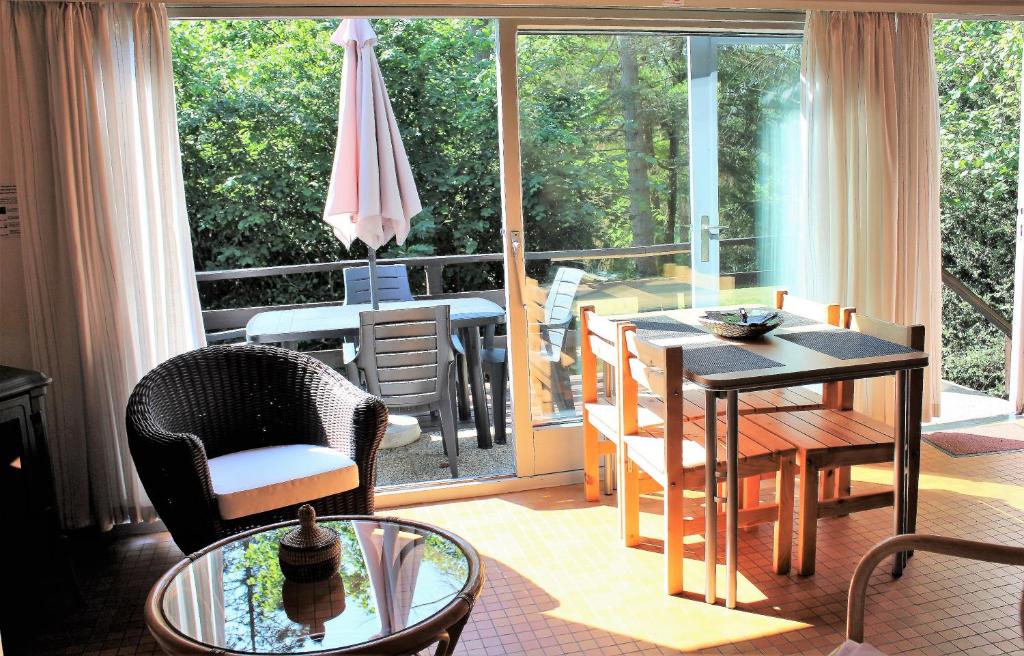 ein Wohnzimmer mit einem Tisch und Stühlen auf dem Balkon in der Unterkunft Au bois charmant in Waulsort