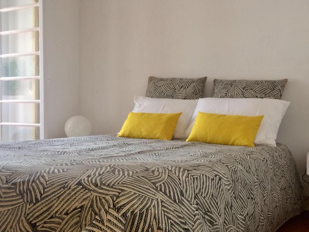 a bedroom with a bed with two yellow pillows at Sant'Ana Guest House in Leiria