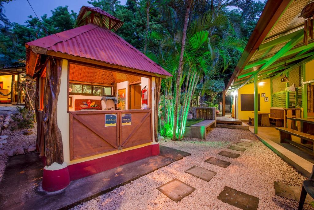 una pequeña casa con techo rojo en un patio en Indra Inn, en Playa Grande
