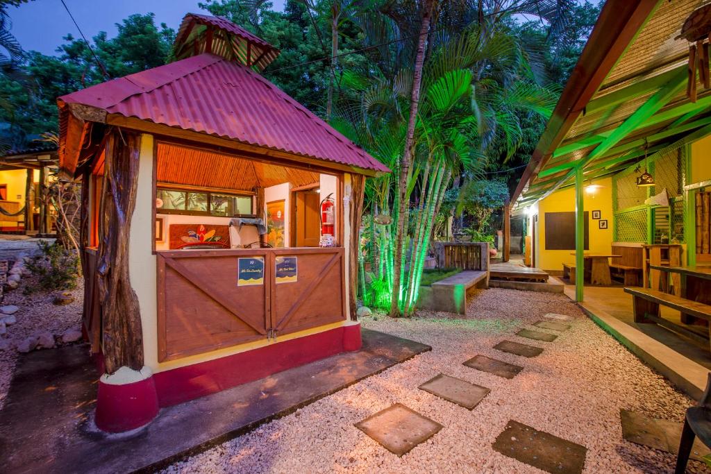 une petite maison avec un toit rouge dans une cour dans l'établissement Indra Inn, à Playa Grande