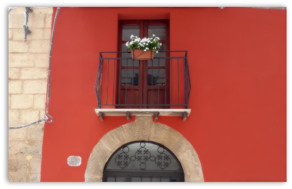シャッカにあるCasa Giavada Steripintoの赤い建物(窓、バルコニーに花鍋付)