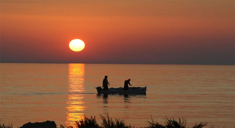 two people in a boat in the water at sunset at Vacation Home Katarina in Nin