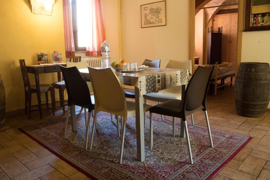 un comedor con mesa y sillas sobre una alfombra en Lo Sfizio B&B, en Cupramontana