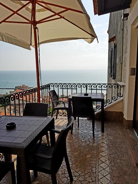 taras ze stołami, krzesłami i parasolem w obiekcie B&B Porta Marina w mieście Grottammare