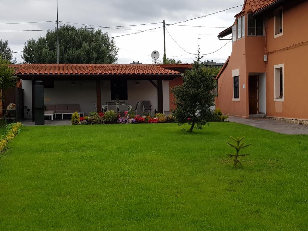 a yard in front of a house with green grass at Casa Urondo Barri in Erandio