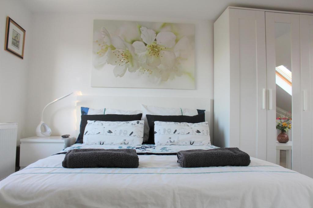 um quarto com uma grande cama branca e 2 almofadas em Jing's Loft Converted Studio em Edmonton