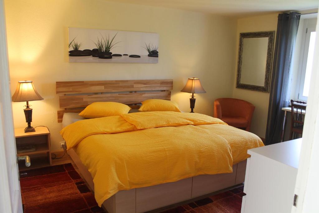 a bedroom with a bed with a yellow blanket at Casa Ortensia in Magadino