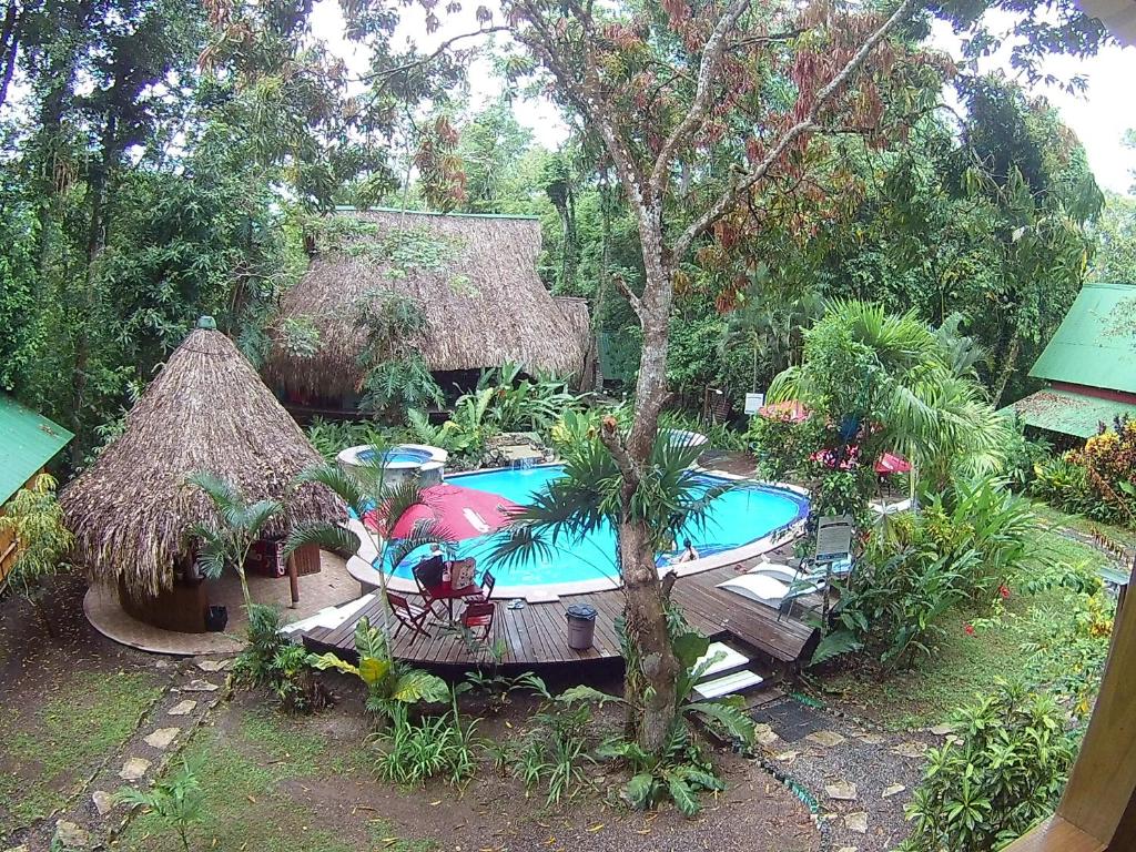 a backyard with a swimming pool and a resort at Hotel Hacienda Tijax Jungle Logde in Rio Dulce