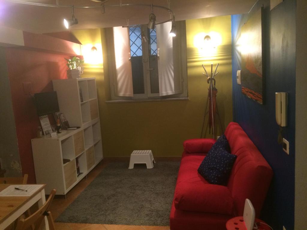 sala de estar con sofá rojo y ventana en Casa Colore, en Nápoles