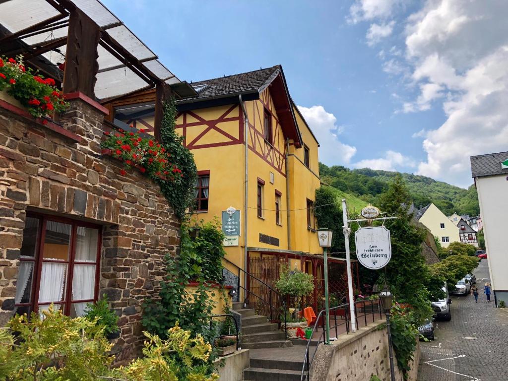 un edificio amarillo con flores a su lado en Zum fröhlichen Weinberg, en Cochem