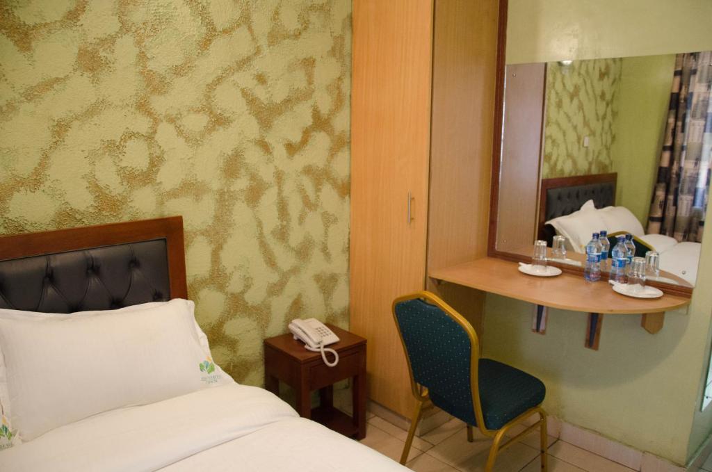 Postel nebo postele na pokoji v ubytování Ash White Hotel