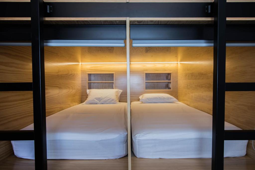 two beds in a bunk bed room with lights at GiG Capsule Hostel in Ericeira